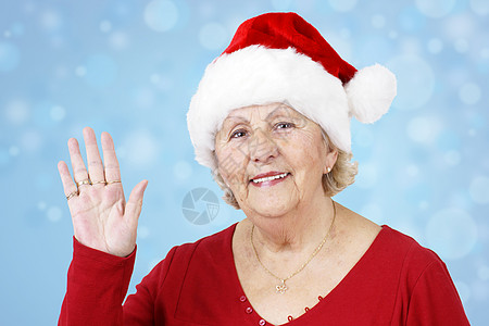 圣诞帽子奶奶挥舞着蓝色图片