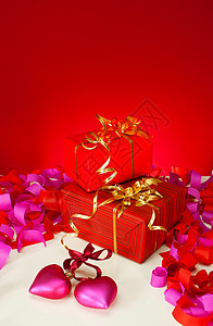 圣情人节的礼物和心在红色背景上图片