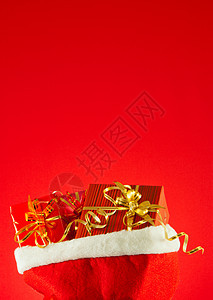 红背景的袋子里圣诞礼物 在包里 丝带 金子 庆典图片