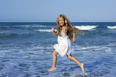 小女孩在蓝海沙滩上跑 支撑 快乐的 海洋 跳跃 头发图片