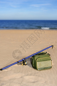 钓鱼在沙滩沙上冲浪投网杆和箱子 爱好 运动图片