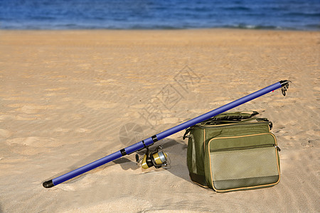 钓鱼在沙滩沙上冲浪投网杆和箱子 自然 娱乐 晚上图片