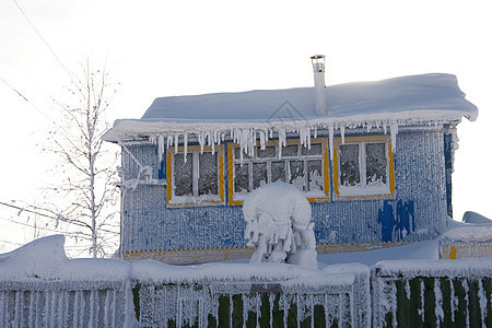 村里有冰棒的雪地小屋图片