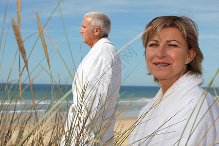 一个在海滩穿浴袍的成熟夫妇图片