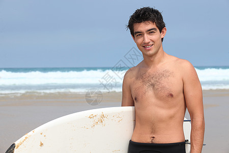 海滩上带冲浪板的年轻人背景图片