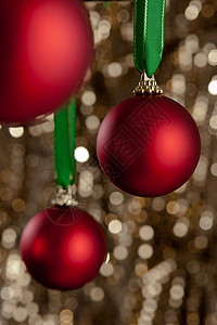 三个红色的圣诞胸围 在金亮闪闪发光的背腹前 闪亮的 玩具图片