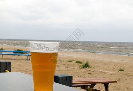 在海边海滩附近的酒吧桌旁 喝着啤酒图片