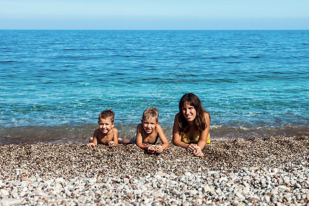 家庭在海边海滩上 支撑 孩子 爱 海洋 女性 天空图片