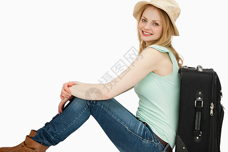 坐在手提箱旁边的微笑的女人 旅游 船夫 金发 享受图片