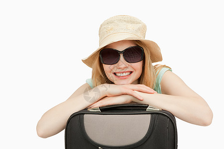 欢乐的女人靠在手提箱上图片