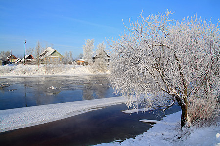 村庄附近的河流冬季冰雪 财产 小屋 舱 天气 窗户图片