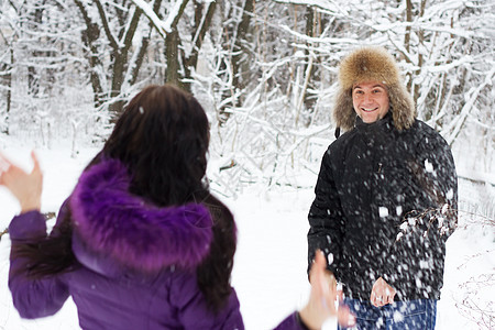 年轻夫妇在冬季公园打鼻涕球图片