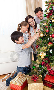 家庭幸福 在圣诞树上装饰鲜花 爸爸 礼物 假期图片