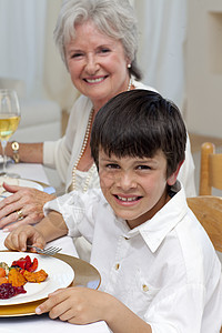 微笑的男孩和家人一起吃晚饭图片