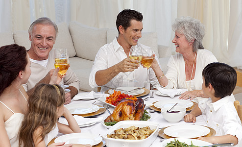 父母亲和祖父母在晚餐中喝着酒 玩弄于股掌图片