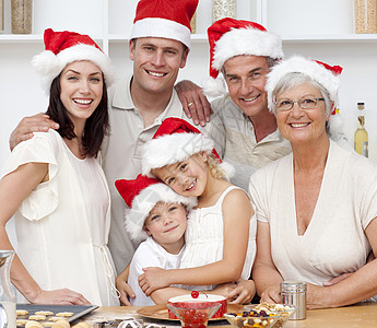 微笑的一家人烤圣诞蛋糕 帮助 祖父母 姐姐 童年 食物图片