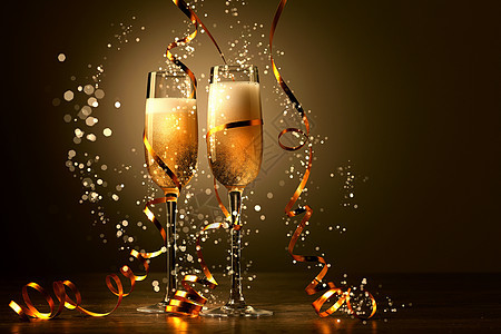 新年派对上香槟的玻璃杯 瓶子 金子 丝带 圣诞灯饰 火花图片