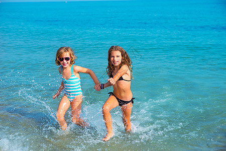 女孩朋友在海滩上一起跑来跑去的 湿的 夏天 海浪图片
