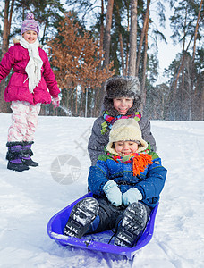 儿童在雪雪地上骑着雪橇 微笑 快乐的 脸 团体 寒冷的图片