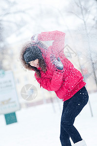 快乐的年轻女人玩雪游戏 手套 假期 灯 脸 冰图片