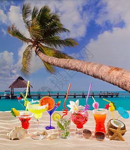 白沙滩上多彩热带鸡尾酒 椰子 夏威夷 莫吉托 饮料 海背景图片