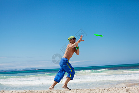 夏天在海滩上玩游骑球的有魅力的男人 游戏 运动图片