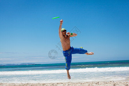 夏天在海滩上玩游骑球的有魅力的男人 健康 幸福高清图片