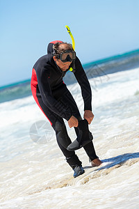 在海滩上戴潜水衣的男性潜水员 身穿潜水服在潜水面罩 爱好 游泳者图片