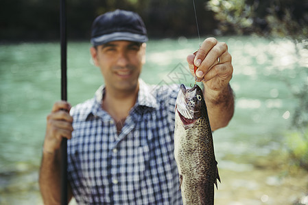 在河上钓鱼 把鱼看镜头 帽子 男人 自然 水 溪流图片