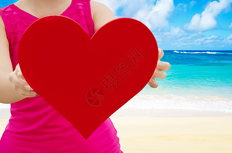 女孩在海滩上抱着心的形状 假期 户外 阳光图片