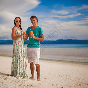 年轻浪漫情侣在沙沙沙滩上放松两杯鸡尾酒 水图片