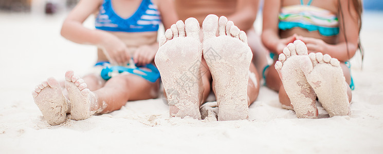 在白沙沙滩上紧贴母亲和两个女儿的脚 成人 海滩图片