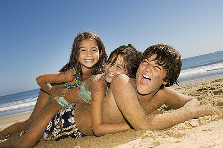 兄弟姐妹们在阳光明媚的一天 在海滩玩得开心图片