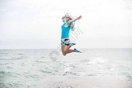 年轻女孩在海滩上跳跃 活力 关心 晴天 天图片
