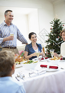 全家在晚餐桌边快乐 圣诞时享受食物图片