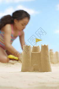 女孩 7-9岁 在沙滩上建造沙城堡 在前方沙城堡中以沙丘为重点图片
