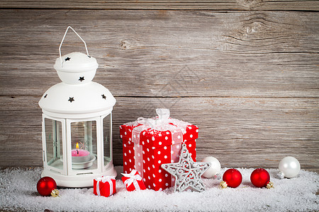 在雪中燃烧灯笼 带有圣诞节装饰品 在木上b 雪花 寒冷的背景图片