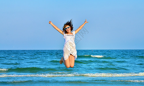 在海滩上跳跃快乐的女孩 天空 海岸 童年 蓝色的 活力图片