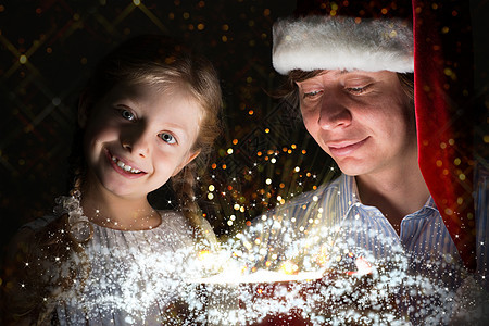 父亲和女儿用礼物打开一个盒子 可爱的 庆典 圣诞节图片