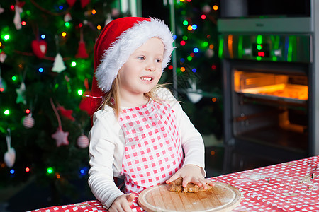 在厨房烤姜饼的可爱小女孩快乐 甜美的小姑娘图片