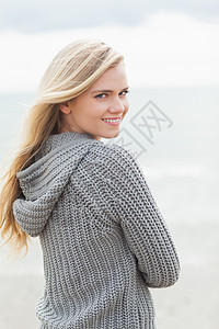 穿着沙滩上灰色针织夹克的可爱年轻女人 海洋图片