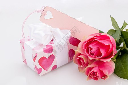 玫瑰摆拍带有空标签的礼品盒 在三朵玫瑰旁边 花束 浪漫背景