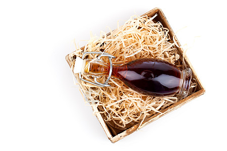 瓶装红酒或草药糖浆 用木制盒装 在白背面上 稻草 礼物图片