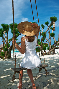 海滩上穿着白衣服的妇女 异国情调 蓝色的 岛 裙子图片