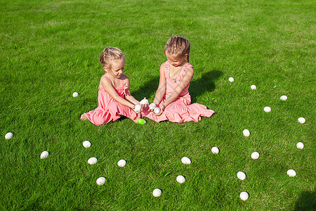 可爱的小女孩在青草上玩复活节鸡蛋 好玩的 婴儿图片