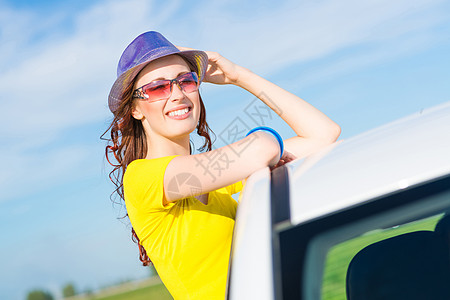 年轻女子走出车窗 女性 天空 司机 夏天 窗户 蓝色的背景图片