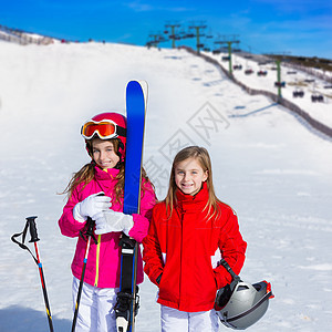 冬季雪上带滑雪设备的小妹妹姊妹 滑雪者 头盔 运动图片