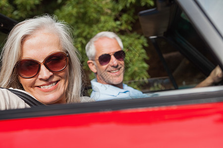 喜悦的成熟情侣驾驶红色轿车的侧面景色 女性图片