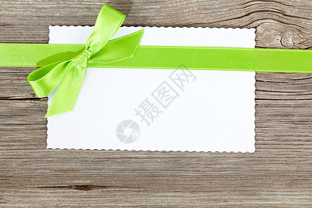木制背景上绿弓的空白纸白纸页图片