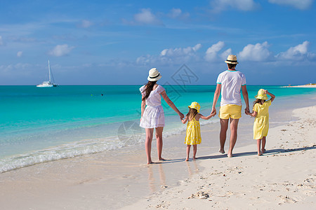 在热带沙滩上四人组成的年轻家庭 父母 女士 姐姐图片